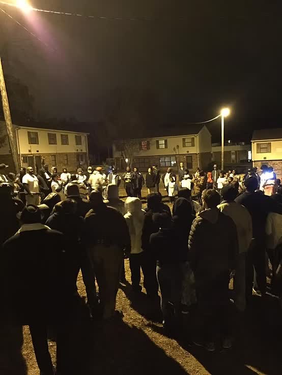 Nighttime outdoor community gathering under streetlights